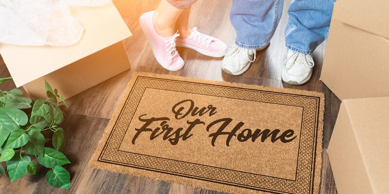 Am I still a first time buyer after I inherit a property? Couple standing by door mat that says "first time buyer". 