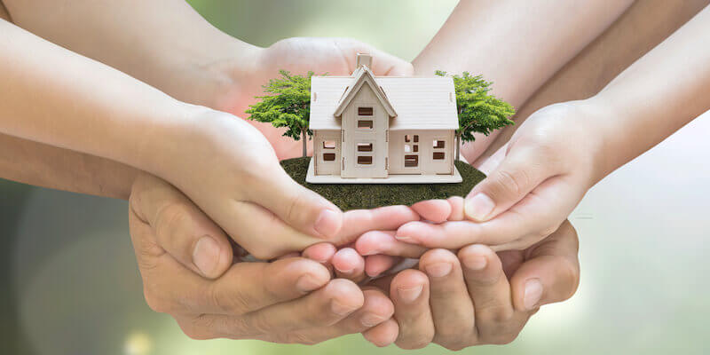 What to do if you inherit a house with a mortgage. Family holding miniature house in hands. 