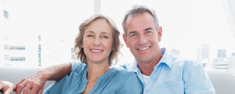 Image of a happy couple on a sofa. Selling your house quickly can be easier and less stressful. 