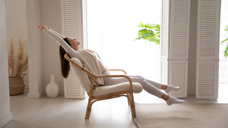 A happy, relaxed lady leaning back on a chair. (Presumably because a company bought her house today and it was so easy)