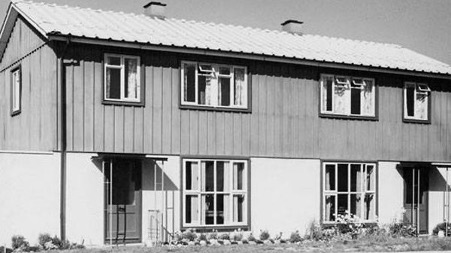 A black and white picture of a pair of semi-detached BISF houses.