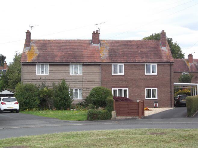 An image of a pair of semi-detached Airey houses, one of which has been repaired.