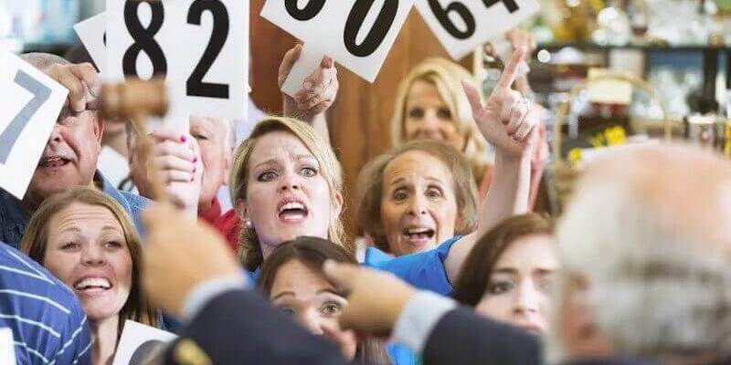 Image of a crowd aggressively bidding on an auction property